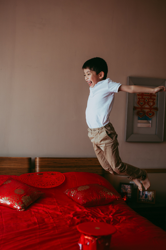 Kid jumping on bed, part of Chinese wedding tradition